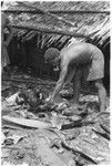 Man with pig head on pile; the head is sacred