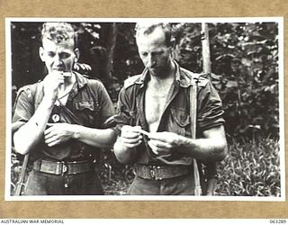 FAITA AREA, NEW GUINEA. 1944-01-07. NX106310 TROOPER J. P. HALLINAN OF GLEN INNES, NSW (1) AND LANCE CORPORAL M. L. WHEATLEYOF PERTH, WA (2) OF THE 2/2ND COMMANDO SQUADRON WHO HAVE JUST RETURNED ..