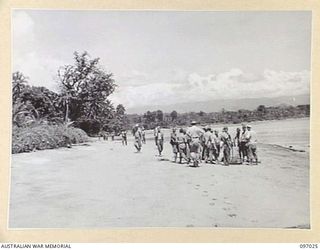 JAPANESE TROOPS BRINGING EQUIPMENT ALONG THE BEACH AT MUK MUK IN ACCORDANCE WITH SURRENDER ARRANGEMENTS MADE WITH THE AUSTRALIAN SURRENDER PARTY FROM HEADQUARTERS 2 CORPS WHO ARRIVED AT NUMA NUMA ..