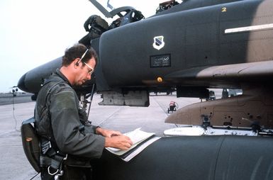 CPT Steve Sloop, a pilot making preflight inspection of his F-4 Phantom II aircraft, looks over a maintenance log. The pilot is from the 3rd Tactical Fighter Squadron, 3rd Tactical Fighter Wing, involved in Exercise Opportune Journey 4