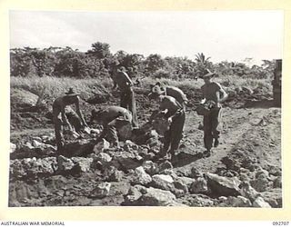 WEWAK AREA, NEW GUINEA. 1945-05-30. ENGINEERS OF 2/2 FIELD COMPANY ROYAL AUSTRALIAN ENGINEERS, CARTING LARGE LUMPS OF CORAL TO FILL IN LARGE BOMB AND SHELL CRATERS IN THE ROAD. IDENTIFIED PERSONNEL ..