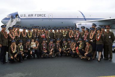 Members of the Chinese People's Liberation Army Air Force Song and Dance Troupe pose for a photograph on a flight line in front of the KC-10A Extender aircraft which will take them back to China. The troupe is here on the final stop of its US tour