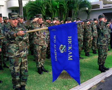 US Air Force members from the current Noncommissioned Officer Academy Class 00-1 stand in formation during a repatriation ceremony at Hickam AIr Force Base, Hawaii. They show their respect as the remains (Not shown), believed to be those of 11 unaccounted for American servicemen are removed from a C-17A Globemaster III (Not shown) during the ceremony on Hickam AFB flight line, November 19th, 1999