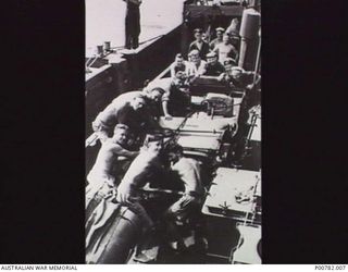 FINSCHHAFEN, NEW GUINEA, 1944-05. RAN PERSONNEL OF HMAS CASTLEMAINE LOADING A JEEP FOR TRANSPORTATION TO MADANG. (DONOR: J. DEEBLE)