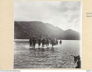 WATU POINT, OPEN BAY, NEW BRITAIN, 1945-05. TROOPS FROM B COMPANY, 37/52 INFANTRY BATTALION, WADING ASHORE FROM BARGES, AS THEY ARRIVE AT THEIR NEW CAMP SITE TO RELIEVE 36 INFANTRY BATTALION. THE ..