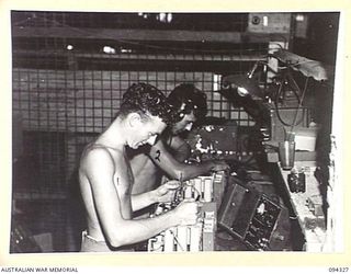 TOROKINA, BOUGAINVILLE. 1945-07-25. SIGNALMAN S. BYRNE (1) AND SIGNALMAN S. KERKENZER (2), TESTING WIRELESS SETS IN THE SIGNAL EQUIPMENT SECTION OF 16 ADVANCED ORDNANCE DEPOT