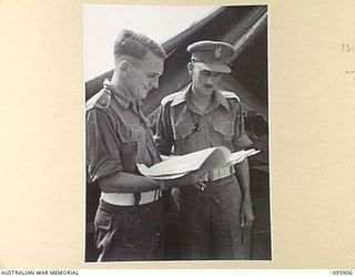 WEWAK POINT, NEW GUINEA. 1945-08-29. BRIGADIER J.E.G. MARTIN, COMMANDER 19 INFANTRY BRIGADE (2) AND MAJOR J.D. MURRAY, BRIGADE COMMANDER (1), DISCUSSING ADMINISTRATION