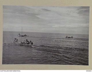 LAE, NEW GUINEA. 1945-05-19. AUSTRALIAN WOMEN'S ARMY SERVICE PERSONNEL ON A LAUNCH TRIP FROM LAE TO SALAMAUA, ORGANISED BY ARMY AMENITIES SERVICE GET THEIR FIRST GLIMPSE OF LAKATOIS (NATIVE CANOES)
