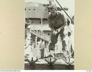 PORT MORESBY, PAPUA, 1944-03-21. TX6217 LIEUTENANT T.L. MOLLOY (1), OF THE 1ST BULK PETROLEUM STORAGE COMPANY, (NEW GUINEA FORCE), MEASURING WITH A DIP TAPE THE REMAINING QUANTITY OF OIL HELD IN A ..