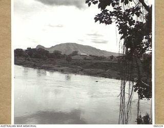12 MILE, LALOKI RIVER, NEW GUINEA. 1943-11-15. LOOKING ACROSS THE RIVER TOWARDS NO. 2 GARDEN AND THE ADMINISTRATIVE BUILDINGS OF THE 3RD AUSTRALIAN FARM COMPANY, AUSTRALIAN ARMY SERVICE CORPS