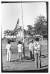 Men gathered beside flagpole