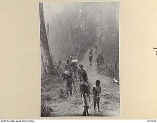 BERRY'S HILL, CENTRAL BOUGAINVILLE, 1945-06-27. A SCENE IN 7 INFANTRY BATTALION AREA. LOOKING DOWN THE TRACK FROM BERRY'S HILL WITH NATIVE CARRIERS MOVING BELOW. THIS WAS THE START OF THE CARRY TO ..