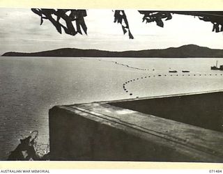 PORT MORESBY, PAPUA. 1944-03-27. THE ANTI-SUBMARINE BOOM VIEWED FROM NO. 13 DIRECTOR PEDESTAL AT PAGA BATTERY, COAST ARTILLERY INDICATING MEASURES TO PROTECT PORT MORESBY HARBOUR
