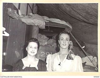 JACQUINOT BAY. 1945-08-17. MISS PEGGY SHEA, A MEMBER OF THE GRACIE FIELDS CONCERT PARTY (1), WITH SERGEANT DONALDSON, HEADQUARTERS AUSTRALIAN ARMY AMENITIES SERVICE (2) PHOTOGRAPHED BACKSTAGE ..