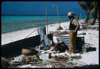 Tearaia Cough Marsters and his "labour", Kainga, forming spear prongs in a temporary forge on the beach on Palmerston Island