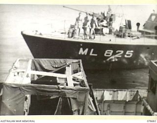 JACQUINOT BAY, NEW BRITAIN. 1945-01-24. THE ML825 OF THE ROYAL AUSTRALIAN NAVY PORT DIRECTORATE, JACQUINOT BAY MOVES IN CLOSE TO THE LCM (LANDING CRAFT MECHANISED) WHICH IS BEING USED AS A TARGET ..