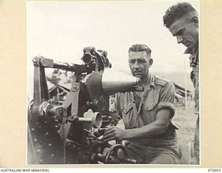 MARKHAM VALLEY, NEW GUINEA. 1944-08-28. VX83131 WARRANT OFFICER 2, T R BURCHALL (1) AND NX47068 SERGEANT R H SMITH (2), 214TH LIGHT AID DETACHMENT, TESTING THE GUN SIGHTS ON A 25 POUNDER GUN OF THE ..