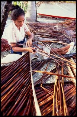 Woman with dried palm fronds, Cook Islands