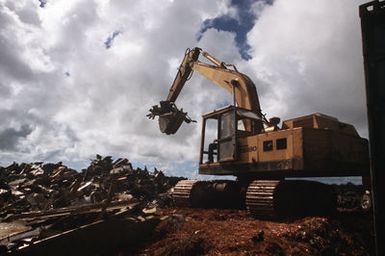 A ditch digging machine lifts scrap metal from what were formerly three B-52D Stratofortess bomber aircraft, discarded in accordance with the SALT II treaty between the United States and the Soviet Union