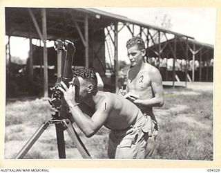 TOROKINA, BOUGAINVILLE. 1945-07-25. WARRANT OFFICER 2 R. HAWKE (1) AND STAFF SERGEANT C. COBDEN (2) MEMBERS OF 16 ADVANCED ORDNANCE DEPOT TESTING AND CHECKING THE TELESCOPES AND THE STEREOSCOPICS ..