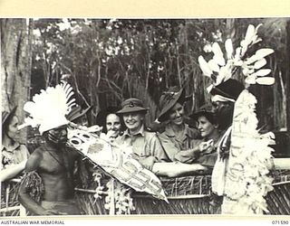 SONG RIVER, FINSCHHAFEN AREA, NEW GUINEA. 1944-03-26. MEMBERS OF THE AUSTRALIAN ARMY NURSING SERVICE ATTACHED TO THE 2/3RD AND 106TH CASUALTY CLEARING STATION ADMIRE THE DRESS OF TWO NATIVE BOYS ..