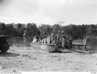 JACQUINOT BAY, NEW BRITAIN. 1945-04-17. JUST DOWN FROM WIDE BAY, BARGE AB2027, MANNED BY MEN OF 41 LANDING CRAFT COMPANY DISCHARGING A CARGO OF MEDICAL GEAR FROM 6 FIELD AMBULANCE, A UNIT WHICH HAS ..