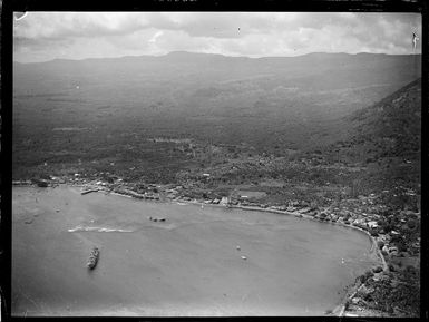 Apia Harbour with freight ships and coastal settlement, with forest covered mountains beyond, Western Samoa
