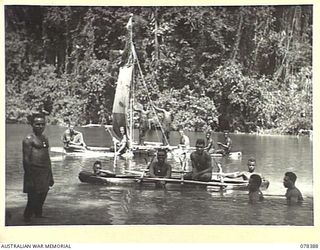 MARAU PLANTATION, NEW BRITAIN. 1945-01-17. EUROPEAN AND NATIVE MEMBERS OF "B" COMPANY, 1ST NEW GUINEA INFANTRY BATTALION HAVING FUN WITH A SAIL RIGGED TALASIA NATIVE LAKATOIS ON THE TAMBE RIVER. ..