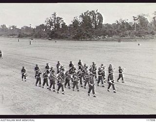 TOROKINA, BOUGAINVILLE. 1945-10-29. THE BAND OF 15TH INFANTRY BRIGADE MOVING TOWARDS THE SALUTING BASE WHERE THE COMMANDER IN CHIEF, AUSTRALIAN MILITARY FORCES, IS TAKING THE SALUTE DURING THE ..