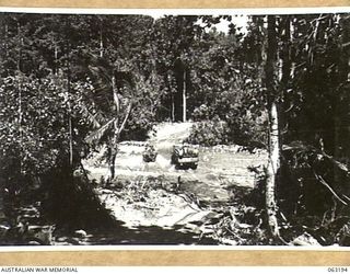 SOWI RIVER, NEW GUINEA. 1943-12-28. ARMY MOTOR VEHICLES CROSSING THE SOWI RIVER