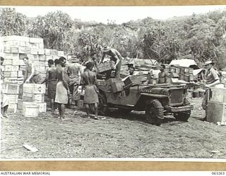 WALINGAI BEACH, NEW GUINEA. 1944-01-02. NATIVES LOADING A JEEP WITH STORES AT THE DUMP OF C COMPANY, 2/48TH INFANTRY BATTALION