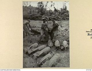 ALEXISHAFEN, NEW GUINEA. 1944-05-11. MEMBERS OF A RMSU (RENDERING MINES SAFE UNIT) RAN, HAULING JAPANESE 100 KILOGRAM AERIAL BOMBS AT ALEXISHAFEN NO. 1 AIRSTRIP. THE BOMBS, SET TO BE FIRED WITH A ..