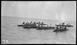 Men paddling canoes