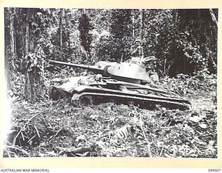 TOROKINA, BOUGAINVILLE, 1945-07-03. AN M24 GENERAL CHAFFEE LIGHT TANK TAKING PART IN TRIALS FOR THE WAR OFFICE HAS LOSS OF TRACTION ON ONE SIDE AS IT TRIES TO CLIMB A SMALL MOUND OF EARTH IN A ..