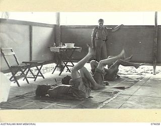 LAE, NEW GUINEA. 1944-07-14. PATIENTS UNDERGOING LEG EXERCISES IN THE PHYSIOTHERAPY DEPARTMENT OF THE 2/7TH AUSTRALIAN GENERAL HOSPITAL SUPERVISED BY TFX6011 LIEUTENANT T.G. SECRETAN (4). THEY ..