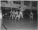 Basketball players jumping for ball, Seattle, December 1948