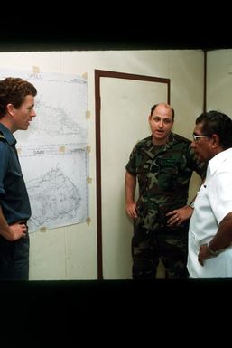 LT Mark Shelvey of the Royal Australian Navy, MAJ Jack Snyder, Detachment 5 Commander for Air Rescue Services, and Sonny Schuster, commissioner of police for the city of Apia, coordinate the distribution of supplies by U.S. Army and Australian helicopters. Supplies will be transported to the islands of Upolu and Savaii during disaster relief efforts in the aftermath of Cyclone Ofa