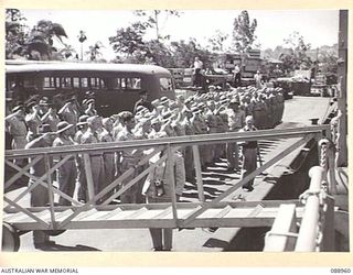 BRISBANE, QLD. 1944-10. FORMER POWS GIVE A FINAL SALUTE TO THE "MONADNOCK", A USN MINELAYER. THE VESSEL CARRIED RESCUED AUSTRALIAN AND AMERICAN POWS FROM GUADALCANAL TO AUSTRALIA