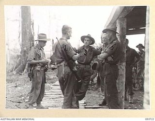 WEWAK AREA, NEW GUINEA, 1945-06-29. MAJ-GEN J.E.S. STEVENS GOC 6 DIVISION (3) SPEAKING WITH LT-COL W.S. HOWDEN (2) WHILE ON AN INSPECTION VISIT TO MOUNT SHIBURANGU AFTER ITS CAPTURE BY C COMPANY, ..