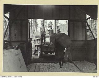 JACQUINOT BAY, NEW BRITAIN. 1945-04-27. A TRUCK LOAD OF MATTRESSES FOR DISTRIBUTION TO CASUALTY CLEARING STATIONS AND HOSPITALS BEING CHECKED BY CAPTAIN PARKER, COMFORTS FUND COMMISSIONER, AT 5 ..