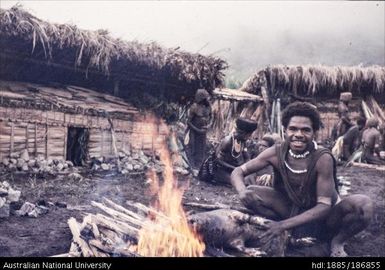 Mendi male sitting at fire, Tend timp