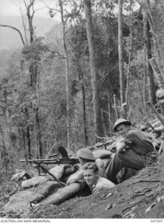 PAPUA, NEW GUINEA. 1942-09. MEN OF THE 55TH AUSTRALIAN INFANTRY BATTALION IN THEIR DEFENSIVE POSITIONS ON UBERI RIDGE, MANNING A .303 BREN MARK 1 LIGHT MACHINE GUN IN A PIT