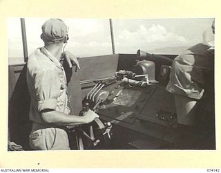 BOISA ISLAND, NEW GUINEA. 1944-06-19. THE SKIPPER AT THE CONTROLS OF AN UNITED STATES NAVY TORPEDO BOAT DURING A PATROL ALONG THE COAST