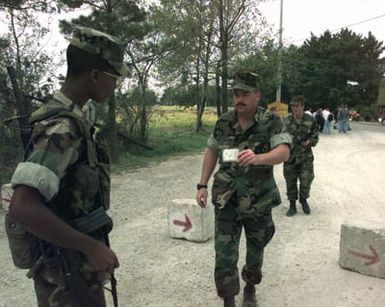 LCPL Cornelius Harrison checks identification badges at the security gate at Marine Expeditionary Camp-Pohang (MEC-P), Oct. 11, 1998. Harrison is out of the Combat Service Support Group, Kaneohe Bay, Hawaii, and is deployed to MEC-P in support of Foal Eagle '98 for two months