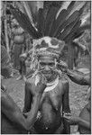 Bride price ritual: bride wears feather and marsupial fur headdress with beetle headband, other women paint her face