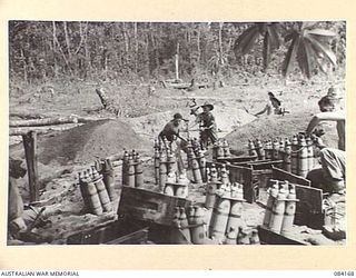 BOUGAINVILLE, SOLOMON ISLANDS. 1944-12-09. D TROOP, 5 FIELD BATTERY, 2 FIELD REGIMENT GUNNERS DIGGING GUN PITS FOR 25 POUNDER GUNS. THE SHELLS AT THE FOREGROUND ARE DRYING AFTER BEING SWAMPED IN A ..