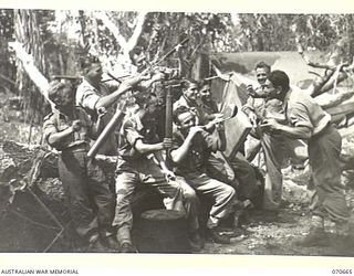 DALLMAN RIVER, NEW GUINEA, 1944-02-25. THE "COOKHOUSE SERENADERS", OF THE 231ST LIGHT AID DETACHMENT, USING COOKING UTENSILS AND A SHELL CASING FOR MUSICAL INSTRUMENTS. IDENTIFIED PERSONNEL ARE: ..