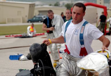 U.S. Air Force AIRMAN 1ST Class Steven Short, a firefighter from the 36th Civil Engineer Squadron, jumps into action while responding to a fire alarm at the Child Development Center at Andersen Air Force Base, Guam, on Jan. 12, 2005. (USAF PHOTO by TECH. SGT. Cecilio Ricardo) (Released)