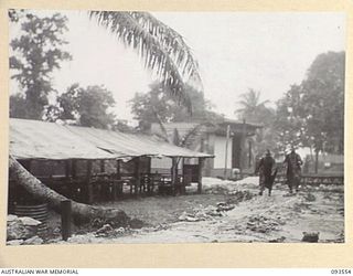 MALMAL VILLAGE, JACQUINOT BAY, NEW BRITAIN. 1945-06-29. AFTER DAYS OF HEAVY MONSOONAL RAIN, THESE TROOPS AT HEADQUARTERS 5 DIVISION WERE GLAD TO GET OUT DURING A SHORT LULL. SHOWN ALSO, MEN'S MESS ..