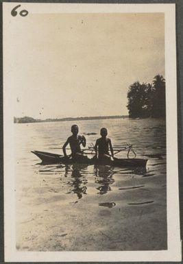 Two Papuan men in a canoe, New Britain Island, Papua New Guinea, approximately 1916